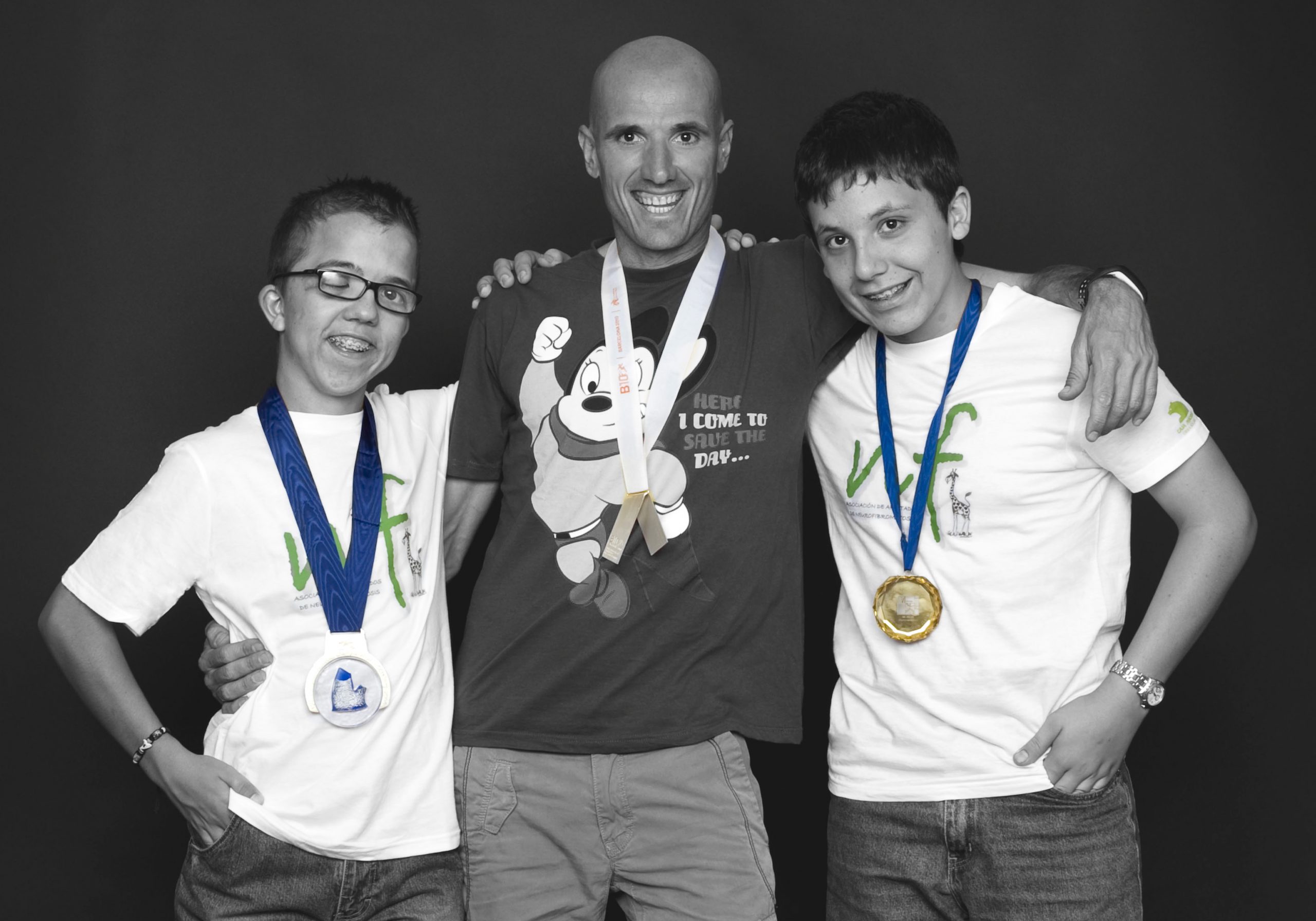El atleta Chema Martínez posando con dos jóvenes de la asociación AANF, mostrando sus respectivas medallas.
